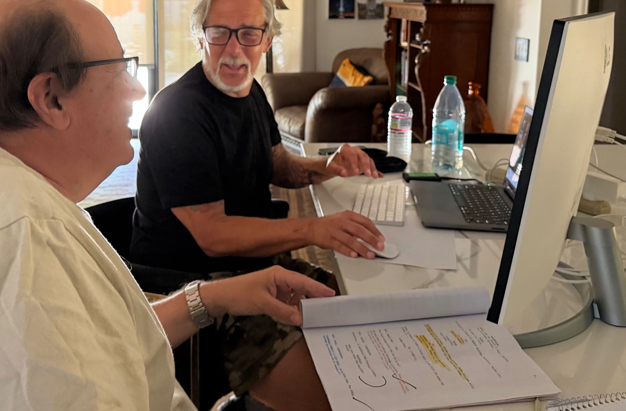 Mark and Bill deep in the script — pages everywhere.